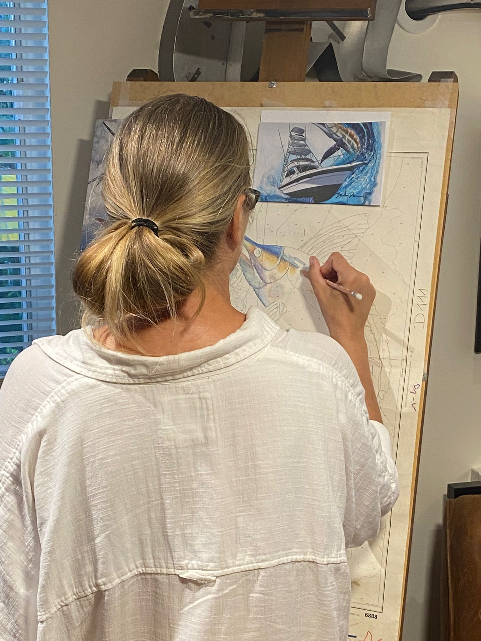 Essebes painting blue marlin on Port of Messina chart